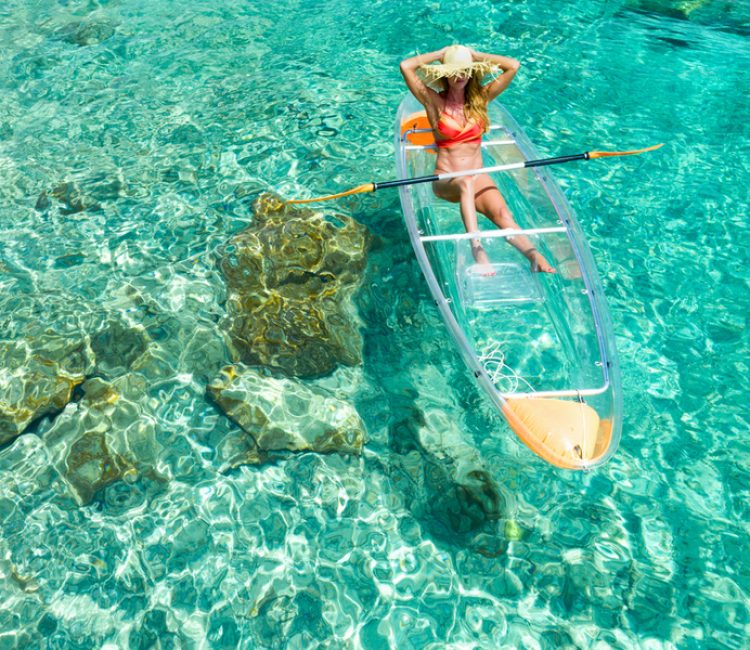 Woman kayaking on clear kayak in tropical water, Congo, Lovango, US virgin islands