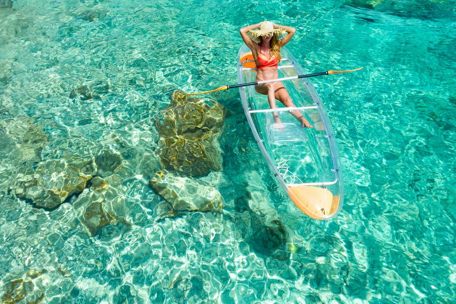 Woman kayaking on clear kayak in tropical water, Congo, Lovango, US virgin islands